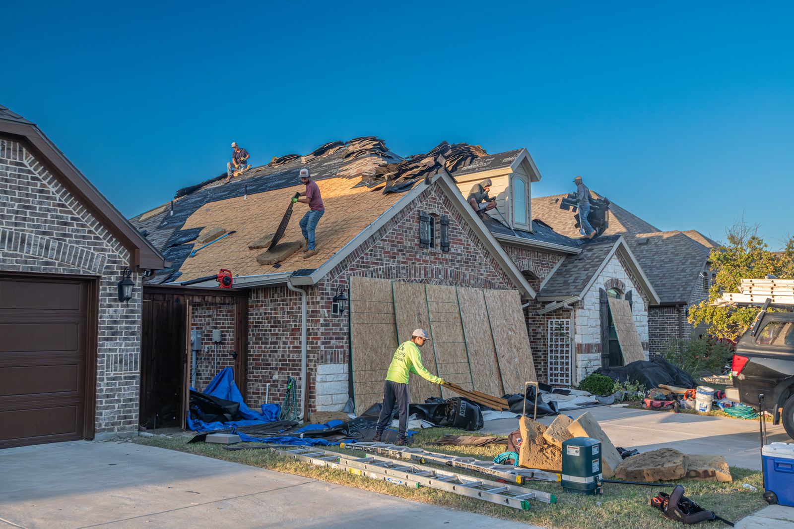 Roof replacement in progress on a brick house